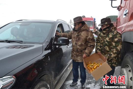 康定市组织应急救援人员给受困车辆驾乘人员免费送食品。 甘孜交警供图
